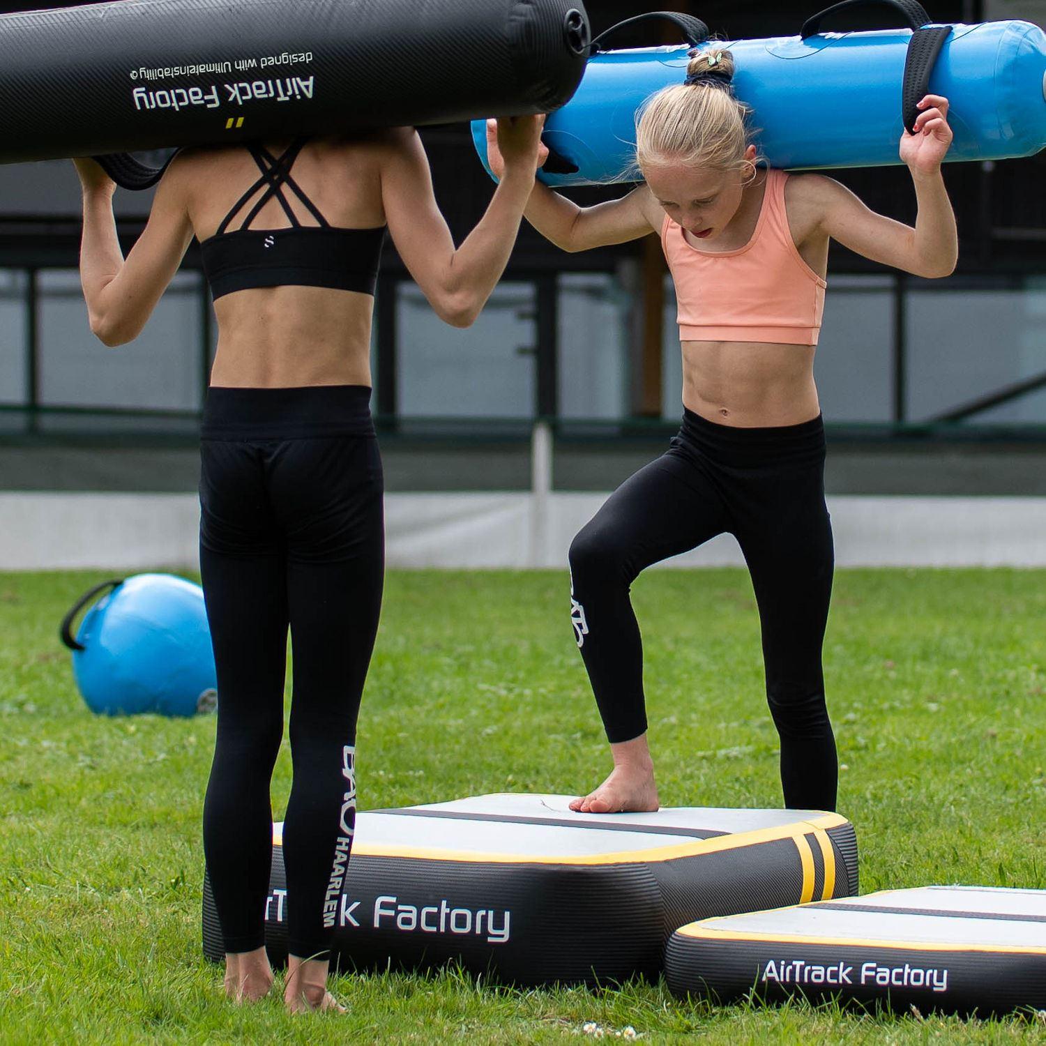 AirBlock - Übung mit Aquabag - Das Air Board wird gerne in Kombination mit anderen AirTrack Produkten genutzt. Bei entsprechender Anordnung auch als "Sprungbrett". AirBlock - Übung mit Aquabag - luftgefülltes AirTrack Kissen